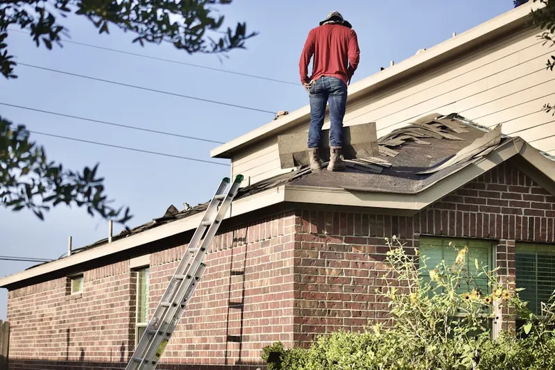 Professional roofer working on a residential roof in Auth Village
